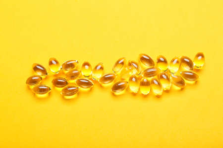 Fish oil capsules on color backgroundの写真素材