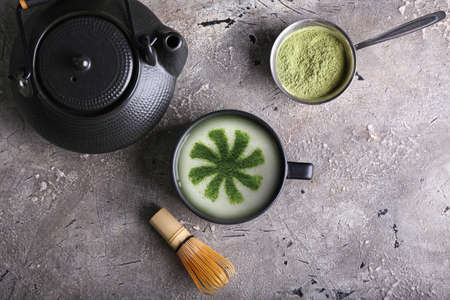 Cup of tasty matcha coffee with powder on grunge background with space for textの写真素材
