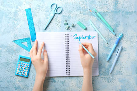 Woman with notebook and stationery on color background. Back to schoolの写真素材