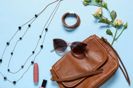 Stylish female accessories with flowers on color backgroundの写真素材