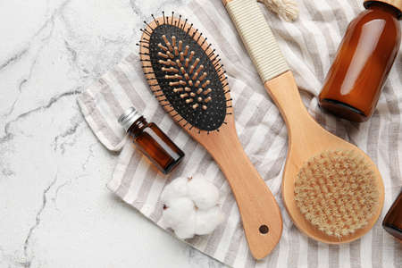 Composition with hair brush and cosmetics on light background