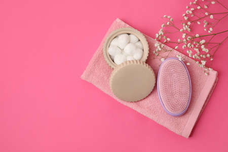 Hair brush, towel and cotton balls on color background