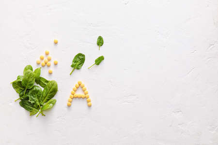 Letter A made of pills and spinach on white backgroundの写真素材