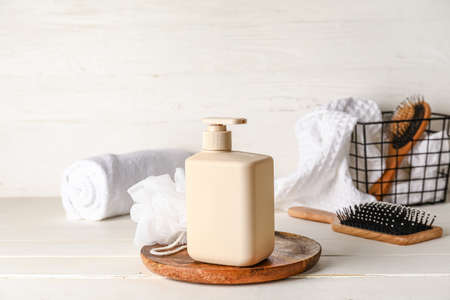 Bottle of shower gel and bath supplies on light background