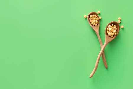 Spoons with pills on color background