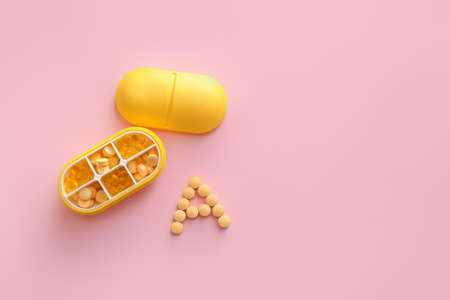 Letter A made of pills and organizer on color backgroundの写真素材