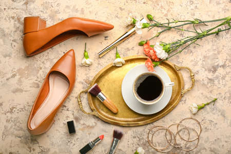 Tray with cup of coffee, flowers and female accessories on grunge backgroundの写真素材