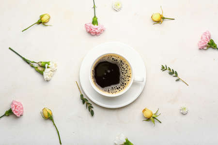 Cup of coffee with spring flowers on light backgroundの写真素材