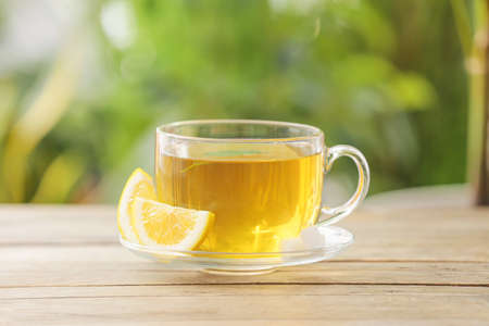 Cup of green tea with lemon on table outdoorsの写真素材