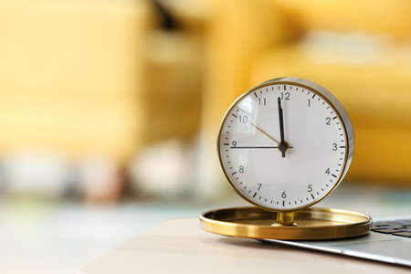 Alarm clock and laptop on table