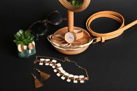 Set of female accessories and houseplant on dark backgroundの写真素材