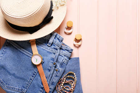 Set of female accessories and clothes on color wooden background
