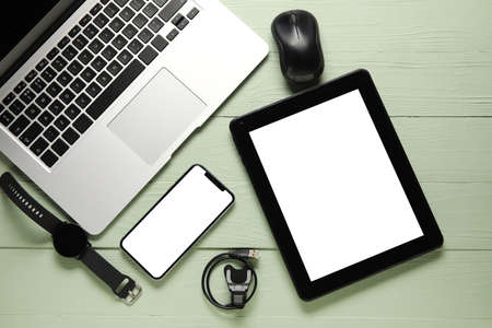 Different modern devices on color wooden background