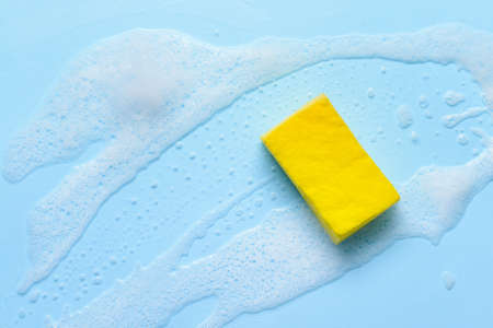 Cleaning sponge with foam on color backgroundの写真素材