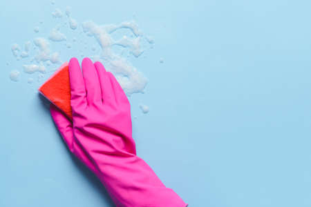Woman with sponge cleaning color surfaceの写真素材