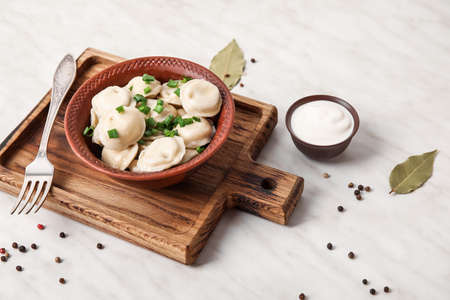 Bowl with tasty dumplings on light backgroundの写真素材
