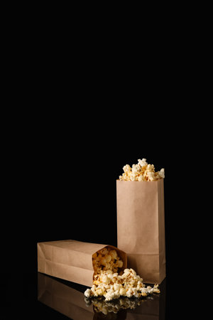 Paper bags with tasty popcorn on dark backgroundの写真素材