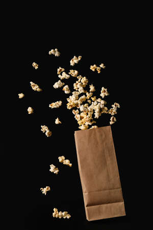 Paper bag with tasty popcorn on dark backgroundの写真素材
