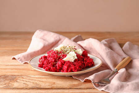 Plate with tasty beet risotto on wooden backgroundの写真素材