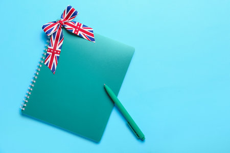 Stationery and ribbon in colors of UK flag on blue background. Concept of learning Englishの写真素材