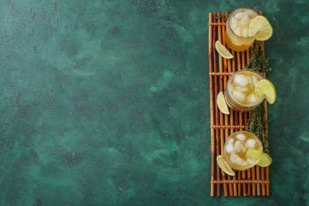 Bamboo mat with glasses of green tea on color background