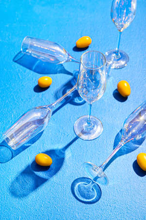 Beautiful empty glasses and kumquat on color backgroundの写真素材