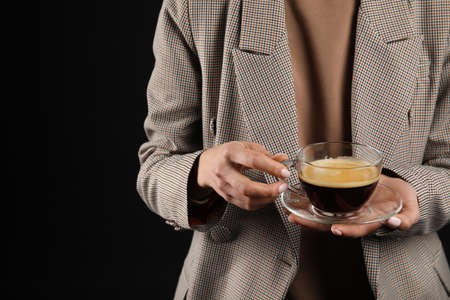 Woman drinking tasty coffee on dark background, closeupの写真素材