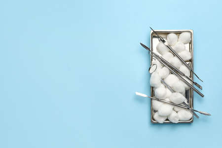 Soft cotton wool and set of dental equipment on color backgroundの写真素材