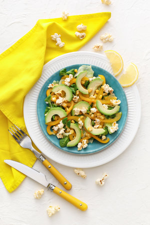 Plate with tasty popcorn salad on light background
