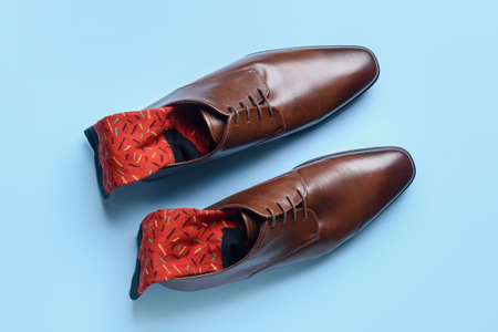 Male shoes with socks on color background