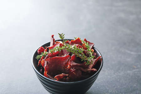 Bowl with spicy beef jerky on dark backgroundの写真素材