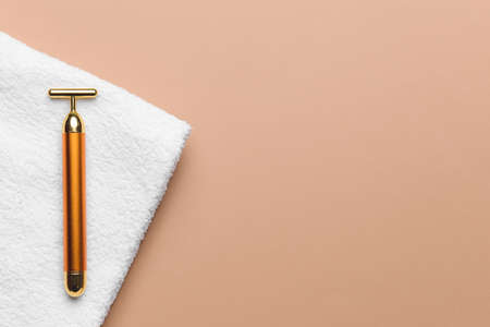 face massage roller with towel on color backgroundの写真素材