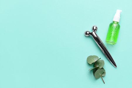 face massage roller with essential oil on color backgroundの写真素材