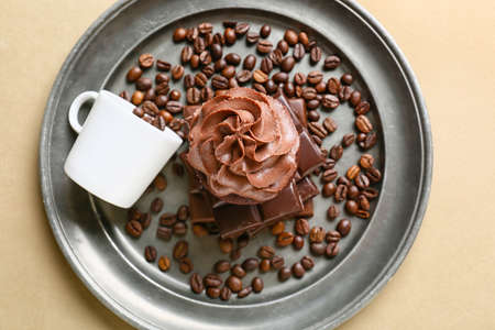 Tray with tasty chocolate cupcake and cup with coffee beans on light backgroundの写真素材