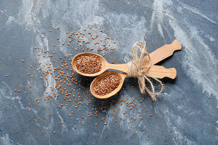 Spoons with flax seeds on color backgroundの写真素材