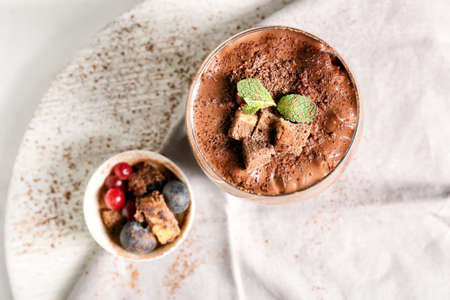 Glass of sweet cocoa dessert on table