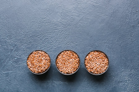 Bowls with raw flax seeds on dark backgroundの写真素材