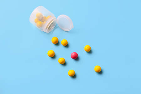 Jar with tasty candies on color background. concept of uniqueness