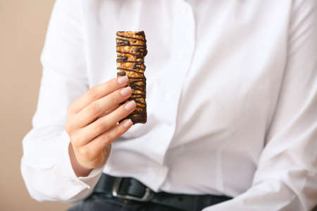 Woman with tasty chocolate nut bar, closeupの写真素材
