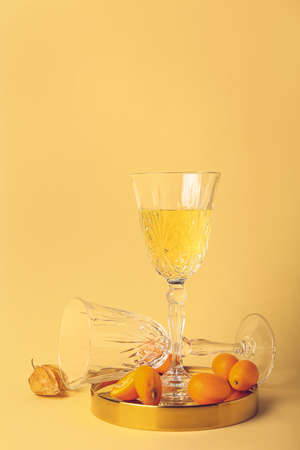 Glass of fresh cocktail with kumquat on color backgroundの写真素材