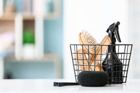 Basket with hairdresser's tools on table in roomの写真素材