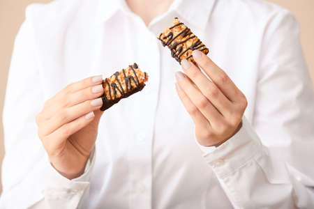 Woman with tasty chocolate nut bar, closeupの写真素材