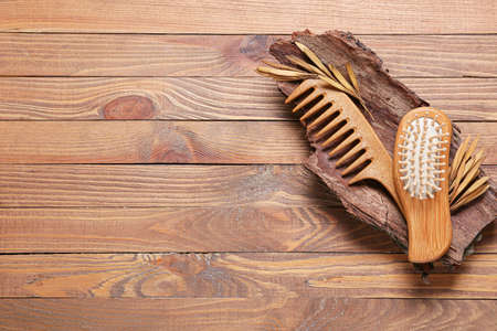 Composition with hair brush, comb and tree bark on wooden backgroundの写真素材
