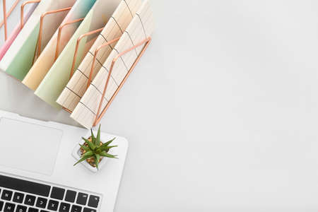 Notebooks with laptop and houseplant on light backgroundの写真素材