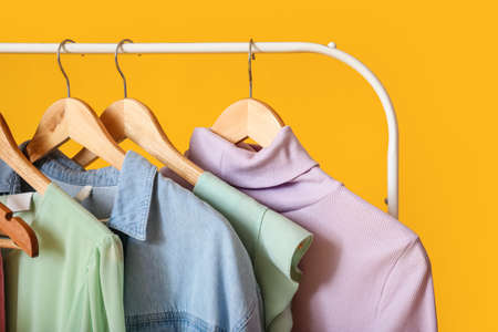 Rack with stylish clothes on color background, closeupの写真素材