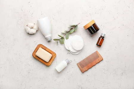 Cotton pads, comb and cosmetic products on light background