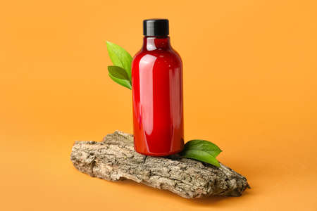 Bottle of shower gel and tree bark on color backgroundの写真素材