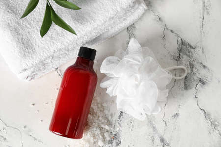 Bottle of shower gel, clean towels and sponge on light backgroundの写真素材