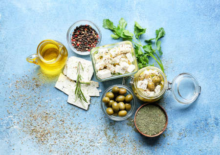 Bowls and jar with tasty feta cheese, oil and olives on color backgroundの写真素材