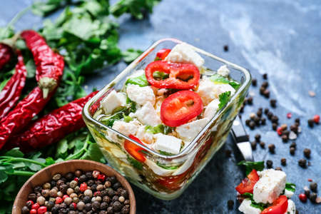 Bowl with tasty feta cheese, oil and herbs on color backgroundの写真素材